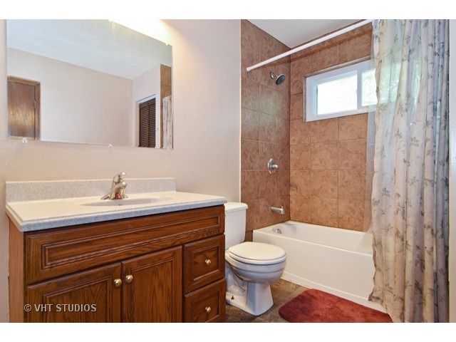 515 Redwood Road Bolingbrook, IL 60440 - Photo 12 of 15 a bathroom with a sink a toilet a mirror and shower