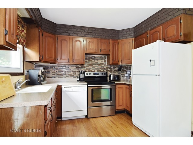 515 Redwood Road Bolingbrook, IL 60440 - Photo 4 of 15 a kitchen with stainless steel appliances granite countertop a stove a sink and a refrigerator
