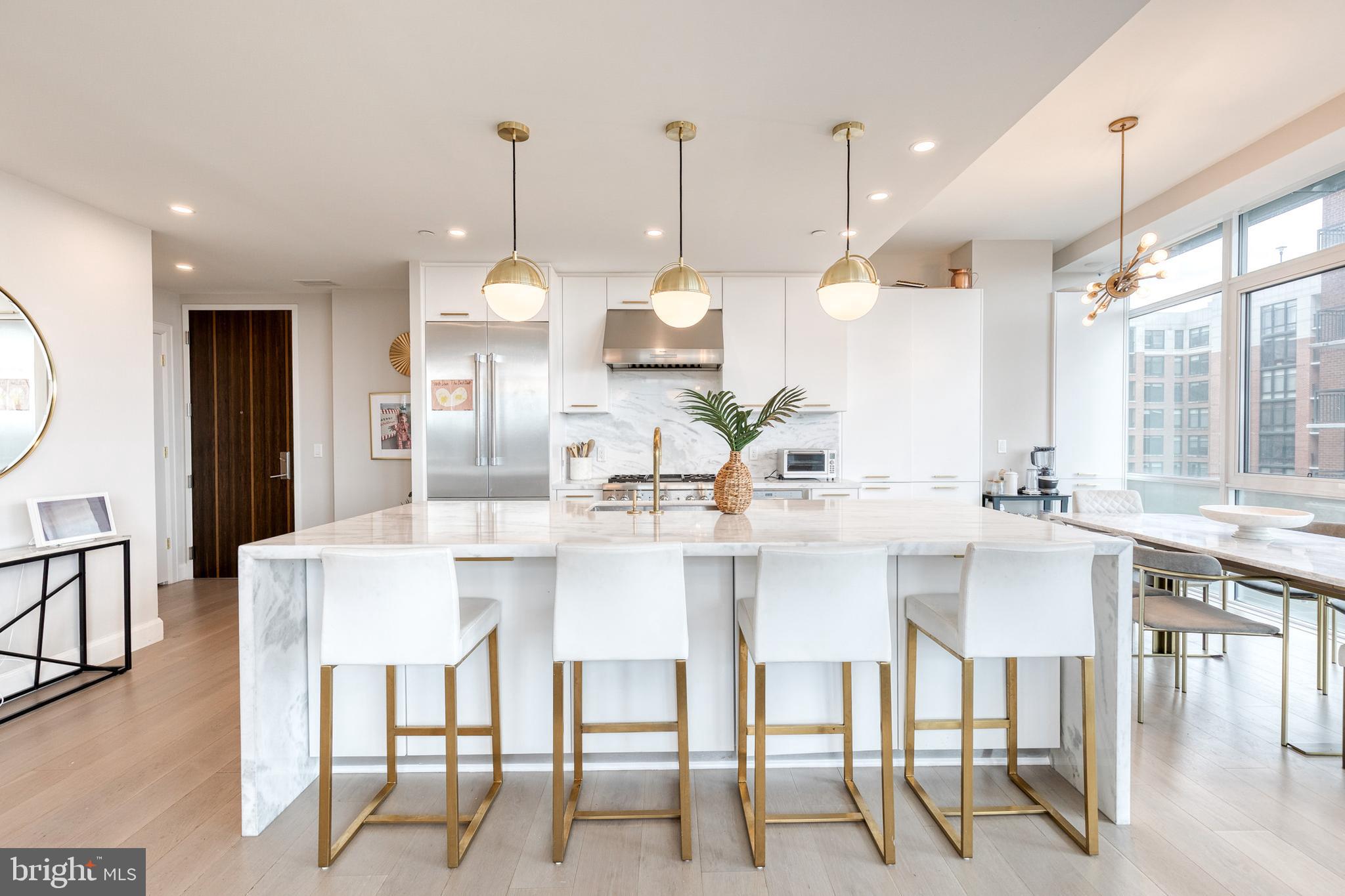 1330 Lancaster Street, Unit C701 Baltimore, MD 21231 - Photo 22 of 73 a kitchen with stainless steel appliances kitchen island granite countertop a table and chairs in it