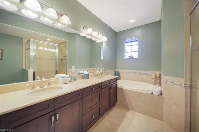 a bathroom with a double vanity sink mirror and bathtub