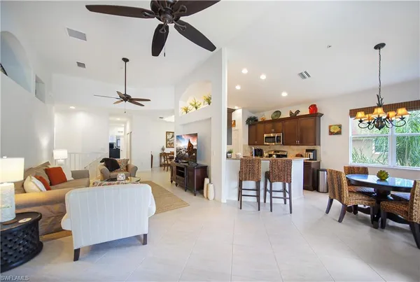 a living room with furniture kitchen view and a chandelier