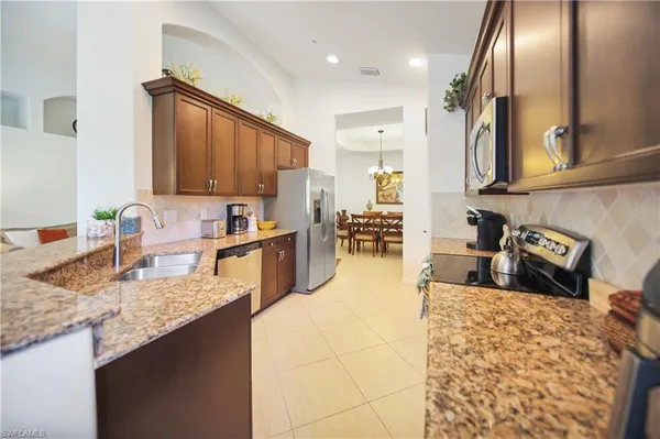 a kitchen with stainless steel appliances granite countertop a sink refrigerator and cabinets