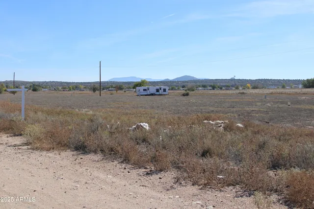 a view of a dry yard with wooden fence