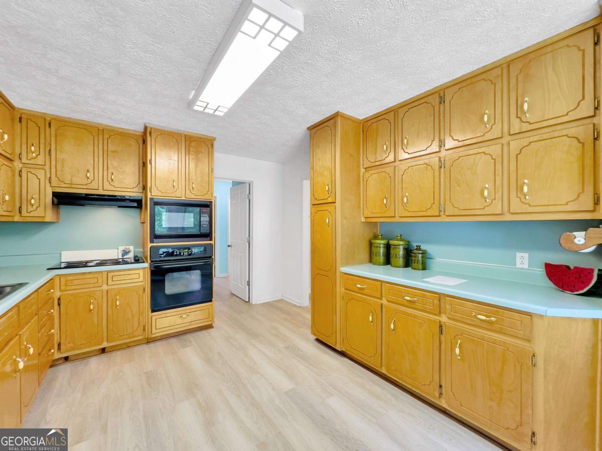 240 Riverview Road Jackson, GA 30233 - Photo 20 of 79 a kitchen with stainless steel appliances granite countertop a sink a stove cabinets and wooden floor