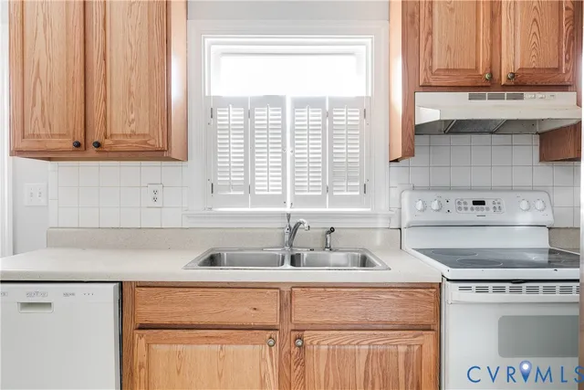 a kitchen with stainless steel appliances granite countertop white cabinets a sink and a stove