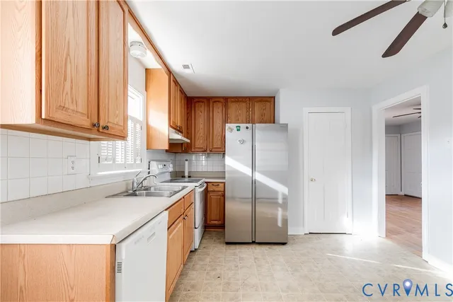 a kitchen with a sink a refrigerator and cabinets