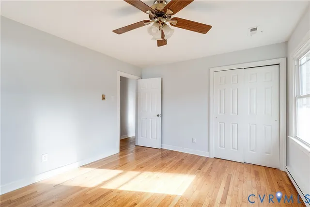a view of a room with a ceiling fan and wooden floor