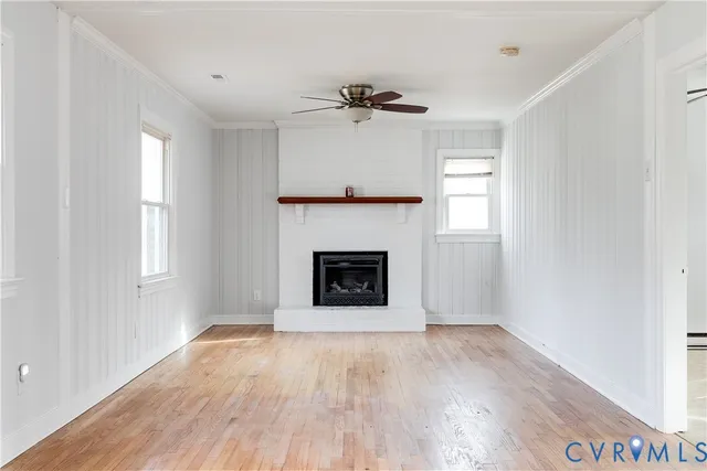 an empty room with windows and a fireplace