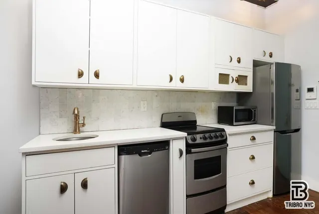 a kitchen with appliances cabinets and a counter top space