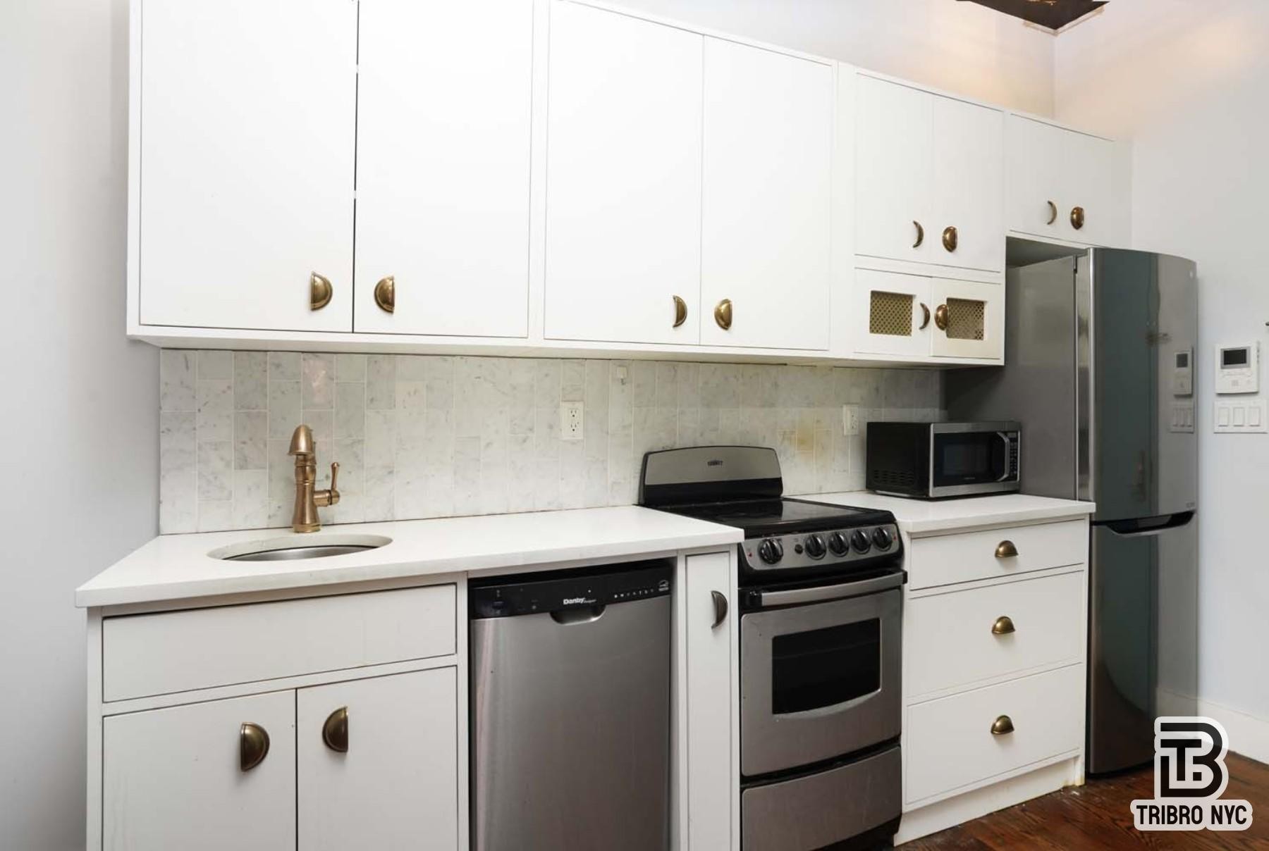 489 Washington Street, Unit 2E Manhattan, NY 10013 - Photo 2 of 7 a kitchen with appliances cabinets and a counter top space