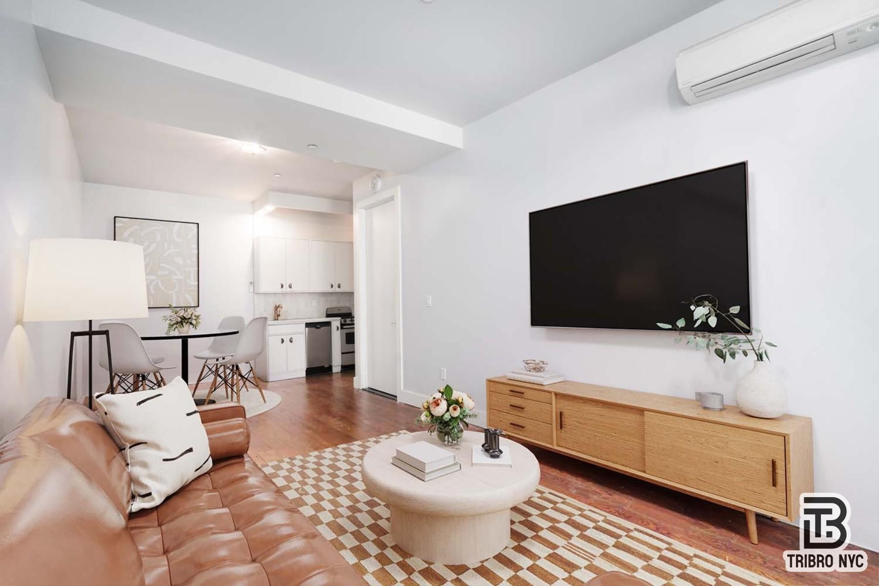 489 Washington Street, Unit 2E Manhattan, NY 10013 - Photo 3 of 7 a living room with furniture and a flat screen tv