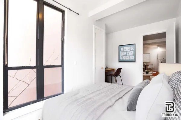 a bedroom with a bed and a large mirror