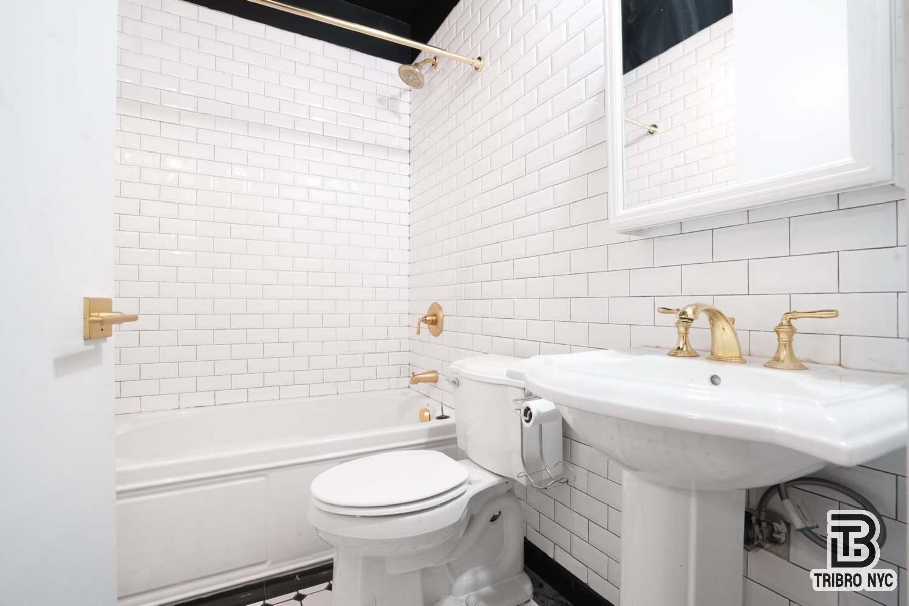 489 Washington Street, Unit 2E Manhattan, NY 10013 - Photo 7 of 7 a bathroom with a sink a toilet and shower