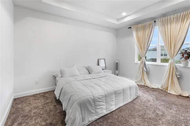 a large bed sitting in a room next to a window