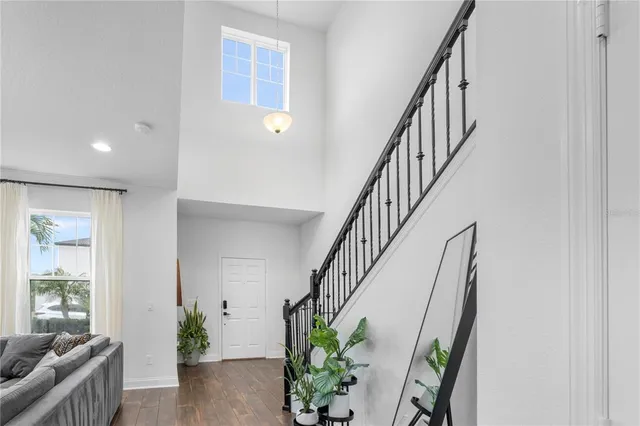 a hallway with wooden floor stairs and furniture