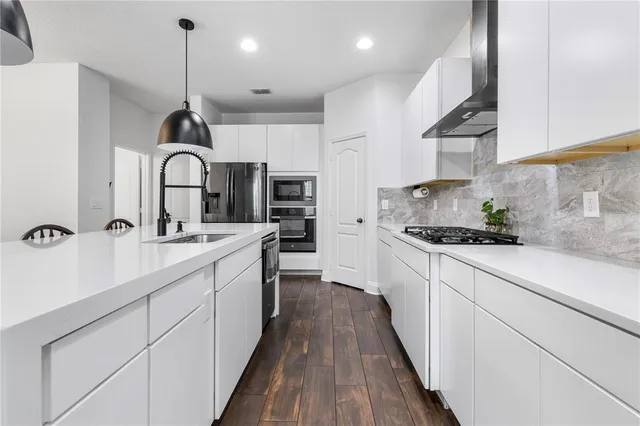 a kitchen with kitchen island granite countertop a sink stainless steel appliances and cabinets