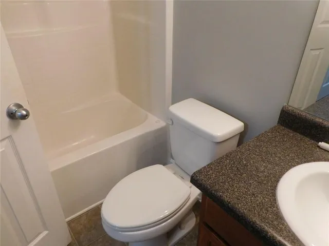 a white toilet sitting next to a bath tub