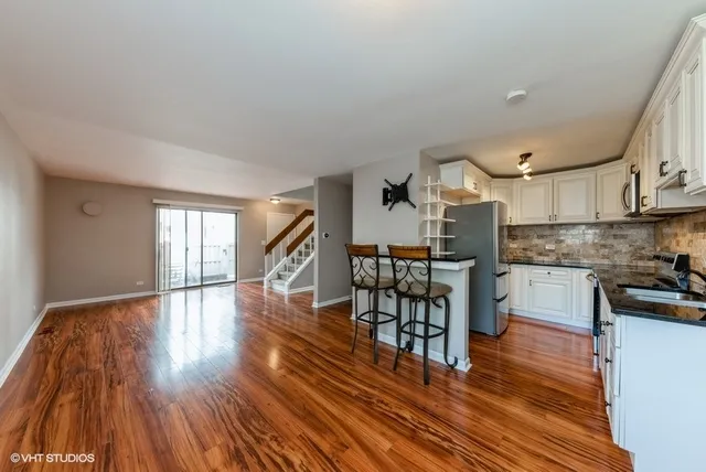 a kitchen with stainless steel appliances a refrigerator and wooden floor