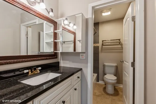 a bathroom with a granite countertop sink toilet and shower