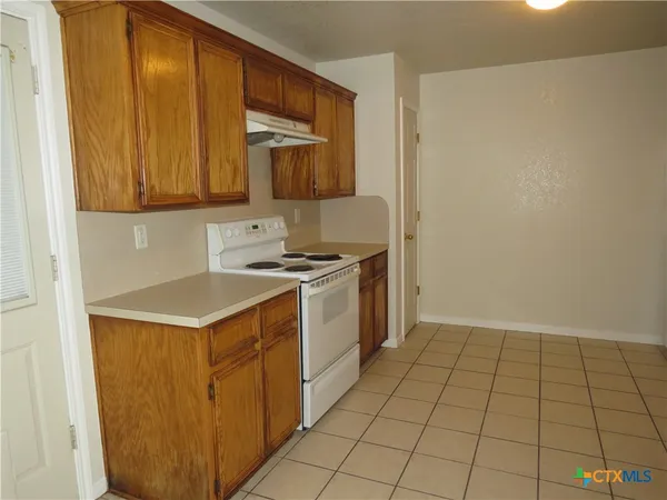 a kitchen with a sink a stove and cabinets