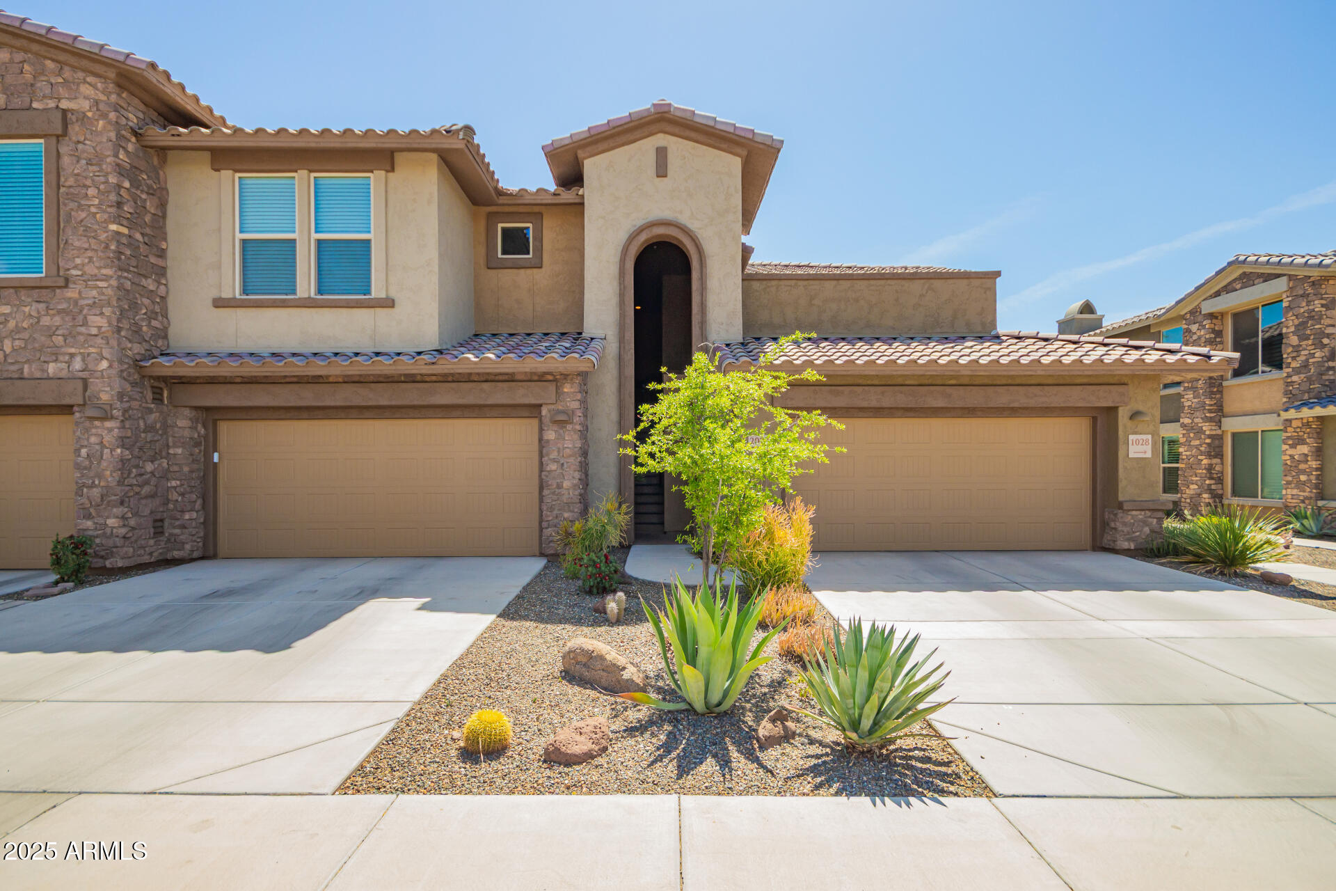 2425 West Bronco Butte Trail, Unit 2028 Phoenix, AZ 85085 - Photo 1 of 46 a front view of a house with a garden and a tree