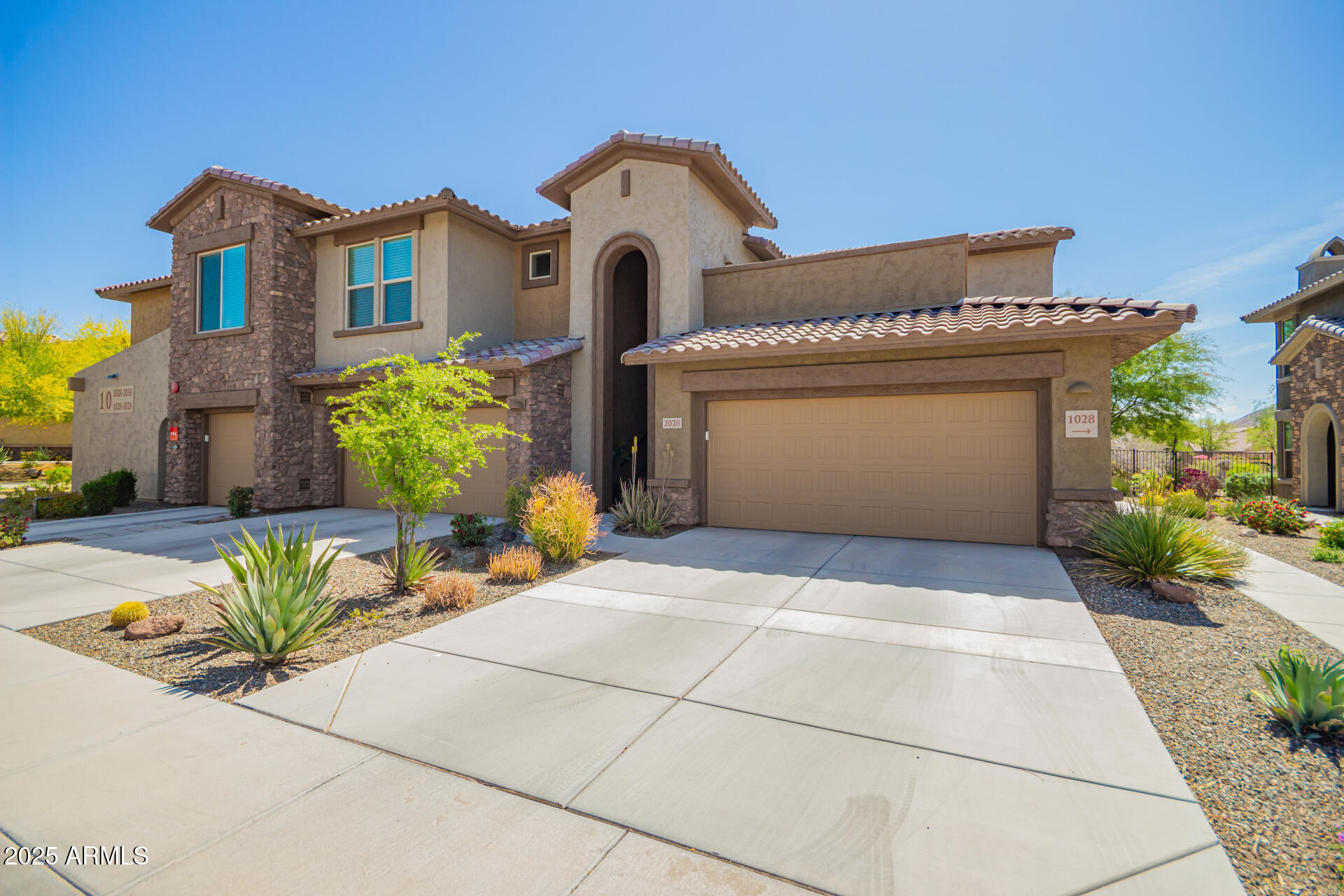 2425 West Bronco Butte Trail, Unit 2028 Phoenix, AZ 85085 - Photo 2 of 46 a front view of a house with a yard and a glass top table