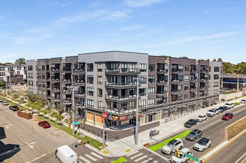 a roof deck with table and chairs and potted plants