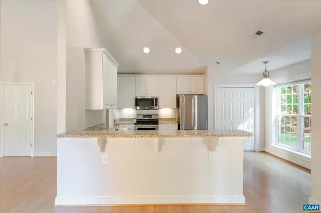 a kitchen with granite countertop a refrigerator sink stove and oven