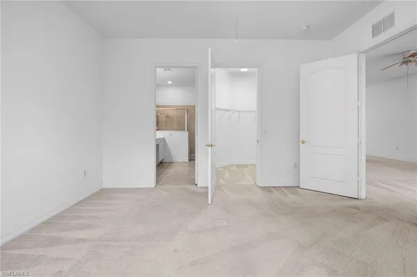 an empty room with a bathroom and mirror