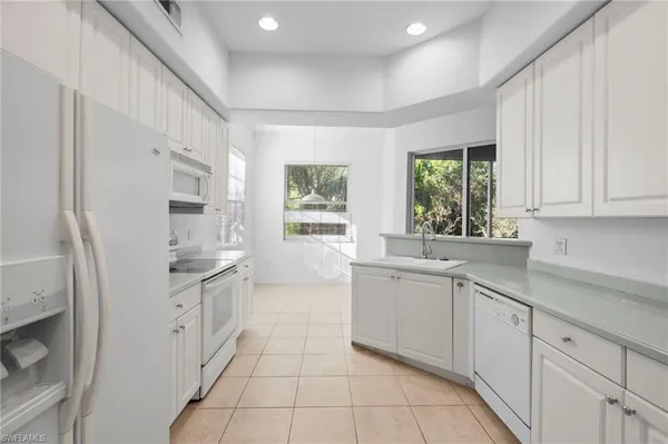 a kitchen with granite countertop a sink stove and refrigerator