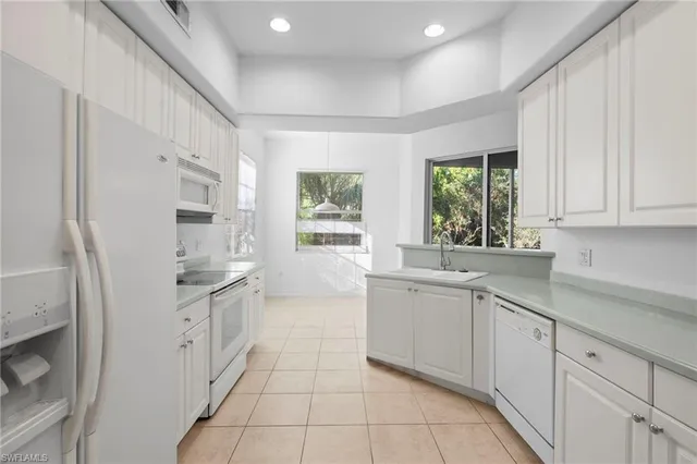 a kitchen with granite countertop a sink stove and refrigerator