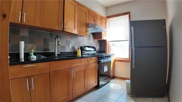 a kitchen with stainless steel appliances granite countertop a refrigerator and a sink