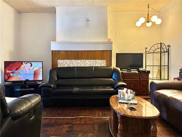 a living room with furniture a flat screen tv and kitchen view