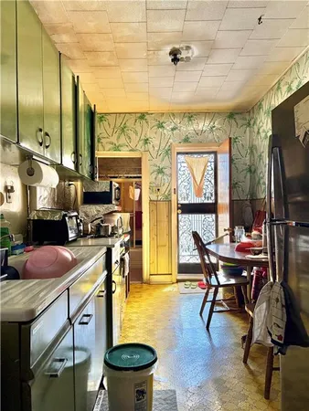 a kitchen with a stove a refrigerator and a dining table