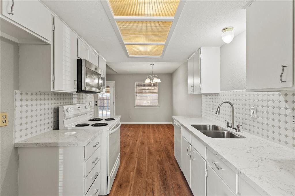 900 Wandering Way Drive Allen, TX 75002 - Photo 19 of 35 a kitchen with stainless steel appliances a sink a stove a microwave and cabinets