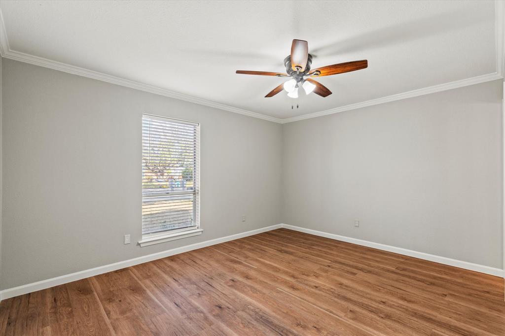 900 Wandering Way Drive Allen, TX 75002 - Photo 20 of 35 an empty room with wooden floor fan and windows