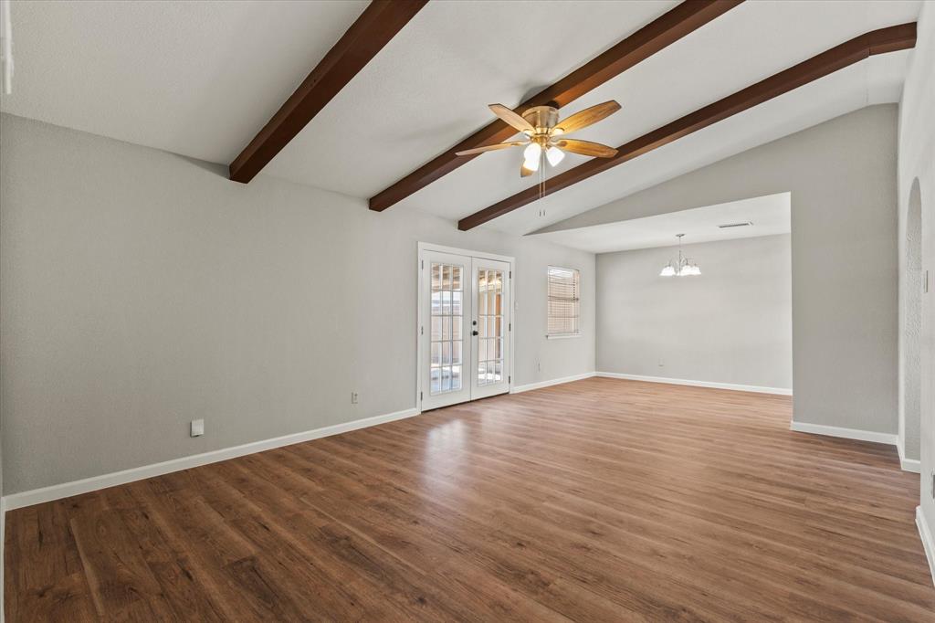 900 Wandering Way Drive Allen, TX 75002 - Photo 7 of 35 a view of an empty room with wooden floor and a ceiling fan
