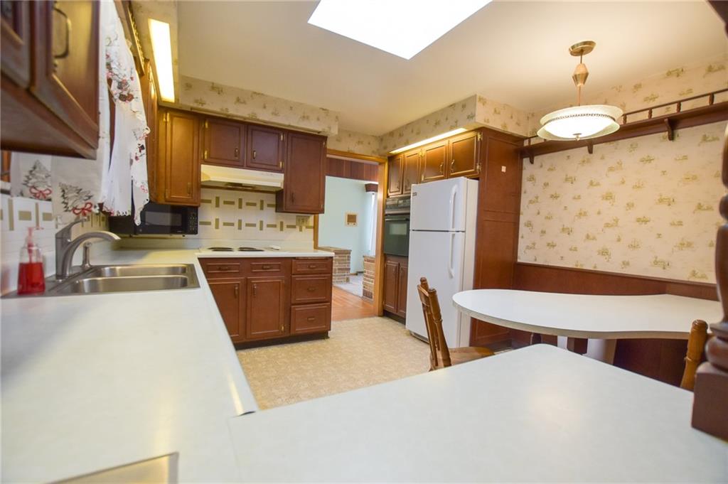 152 Oak Ridge Drive Butler, PA 16002 - Photo 4 of 12 a kitchen with stainless steel appliances a sink a stove a refrigerator cabinets and a dining table