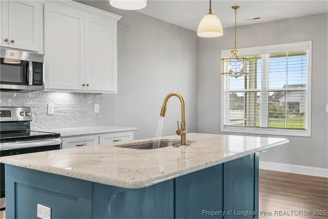 a kitchen with stainless steel appliances granite countertop a sink a oven and a wooden cabinets