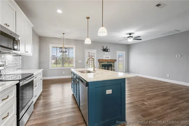 a kitchen with kitchen island a sink counter top space appliances and a window