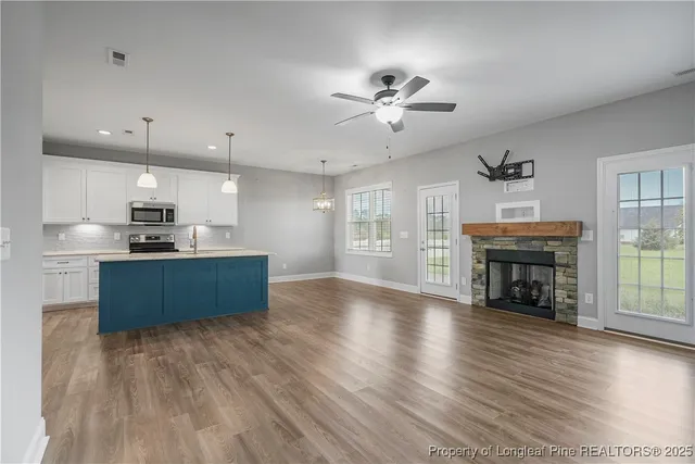 a kitchen with stainless steel appliances wooden floors and view living room