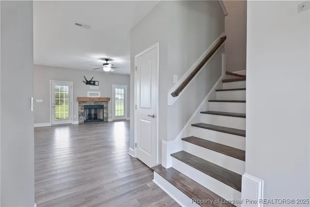 a view of staircase with fireplace and wooden floor