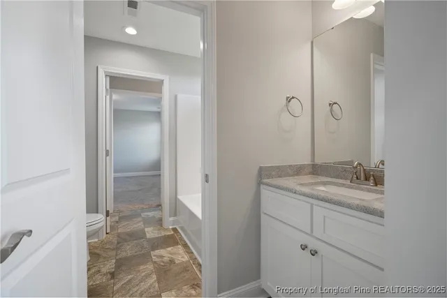 a bathroom with a granite countertop sink a mirror and a shower