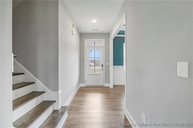 a view of a hallway with wooden floor and entryway