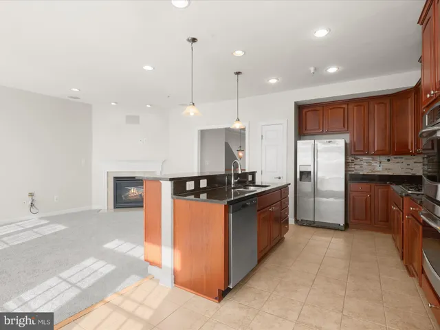 a kitchen with stainless steel appliances granite countertop a refrigerator a stove a sink and a microwave