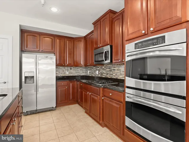 a kitchen with granite countertop a stove a sink and a wooden floors