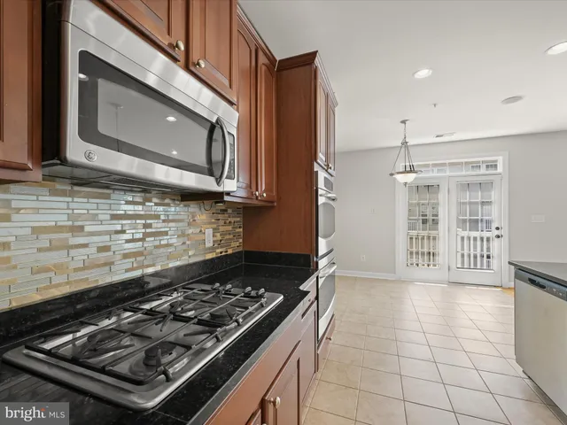 a kitchen with stainless steel appliances granite countertop a stove a refrigerator a sink and a oven