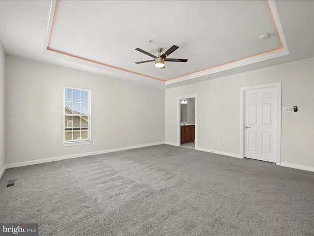 a view of an empty room with a fireplace and a window