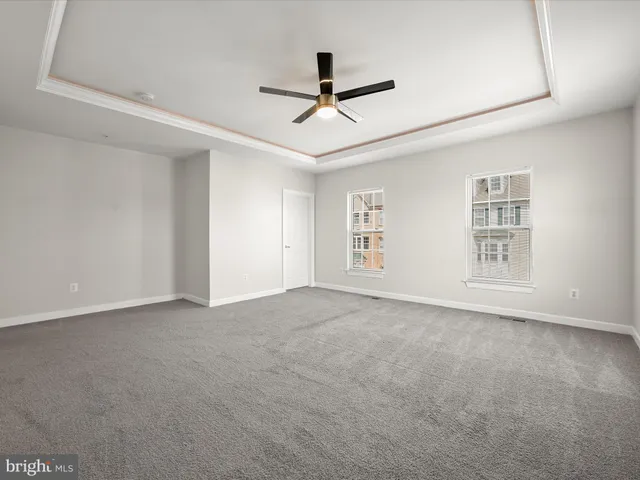 an empty room with windows and ceiling fan