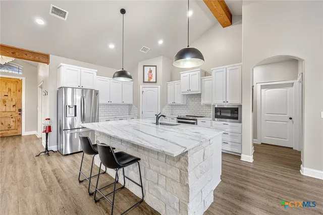 a view of a kitchen with cabinets and wooden floor
